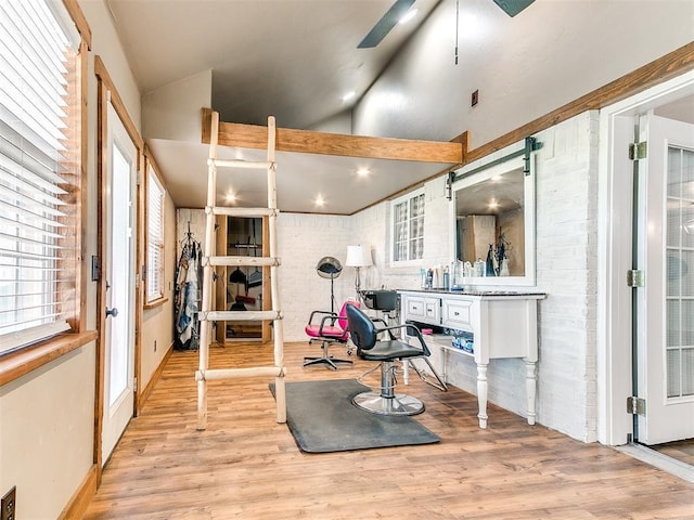 exercise area with lofted ceiling, light wood-style flooring, and a ceiling fan