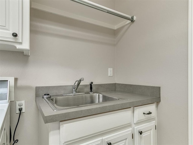 kitchen featuring white cabinetry and a sink