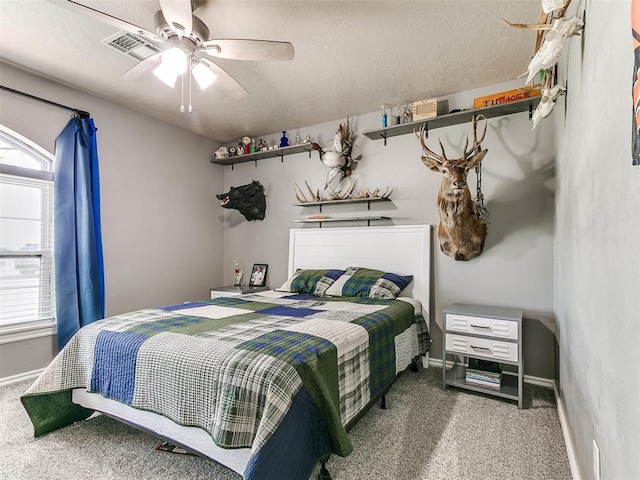 carpeted bedroom with multiple windows, visible vents, baseboards, and ceiling fan