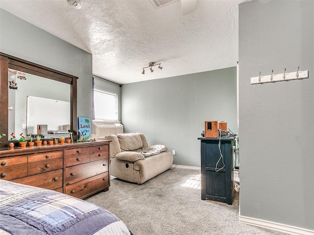 bedroom with carpet, cooling unit, rail lighting, a textured ceiling, and baseboards