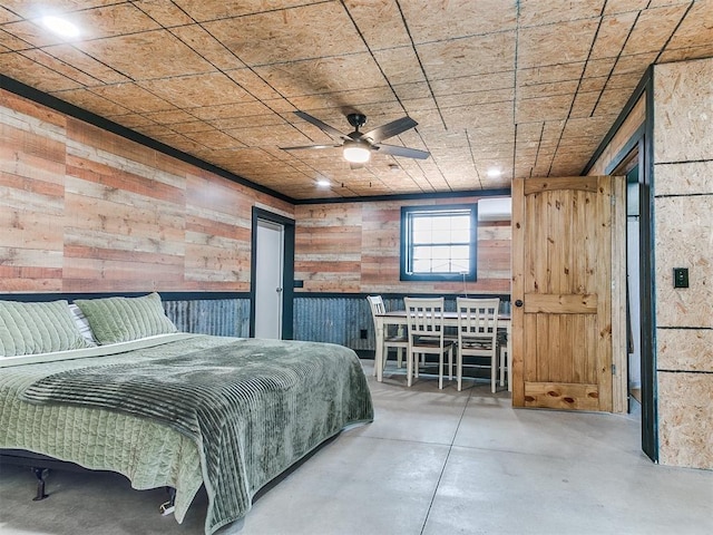 bedroom featuring finished concrete flooring and wooden walls