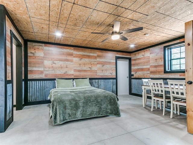 bedroom featuring wooden walls and concrete floors