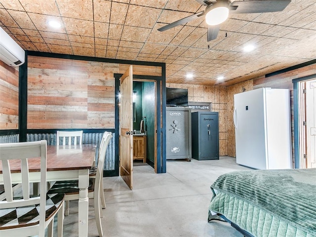 bedroom featuring freestanding refrigerator, a wall mounted air conditioner, concrete flooring, wooden walls, and recessed lighting
