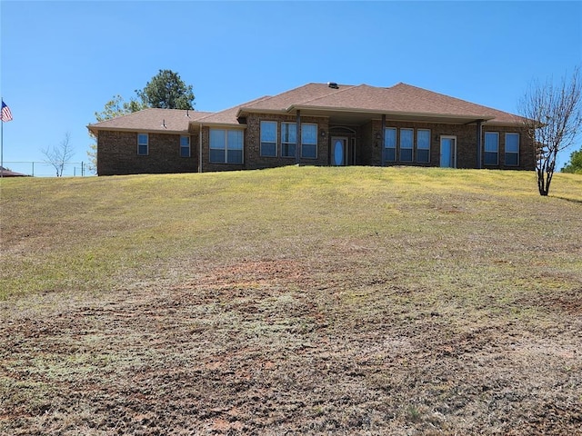 rear view of property with a yard and brick siding