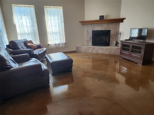 living room with a tile fireplace and concrete flooring