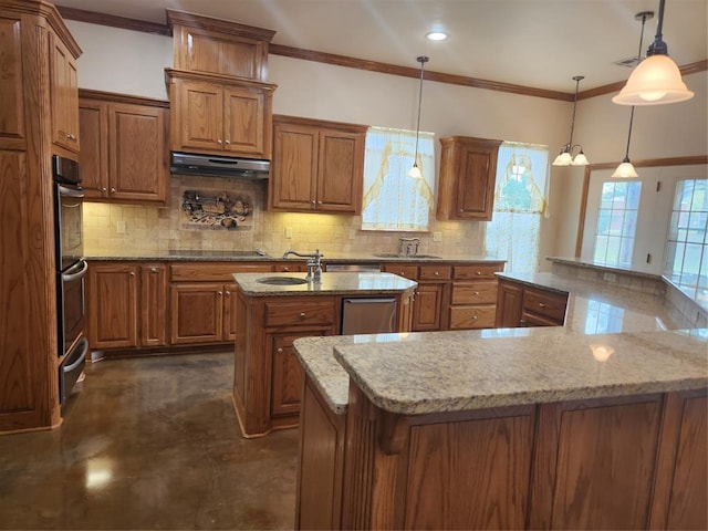 kitchen featuring a large island with sink, under cabinet range hood, brown cabinetry, backsplash, and crown molding