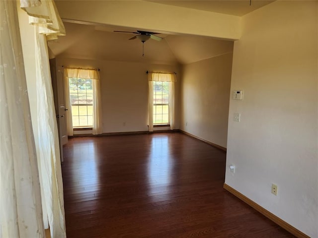 spare room with a ceiling fan, dark wood-style flooring, vaulted ceiling, and baseboards