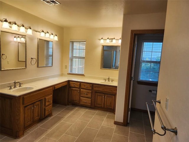 full bath featuring healthy amount of natural light, tile patterned floors, and double vanity