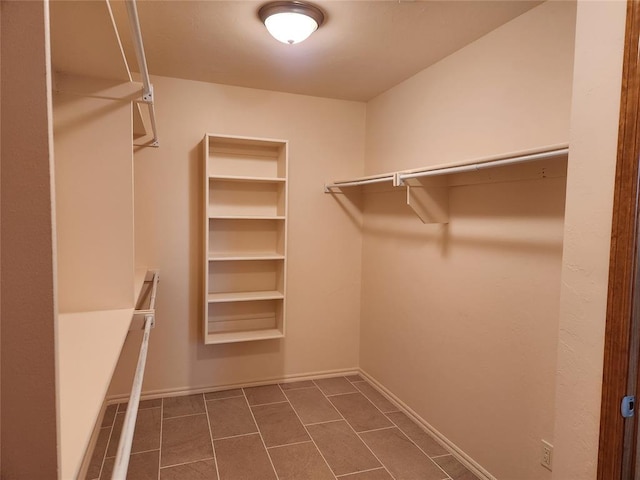 walk in closet with dark tile patterned flooring
