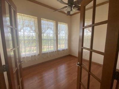 unfurnished sunroom with wood finished floors and baseboards