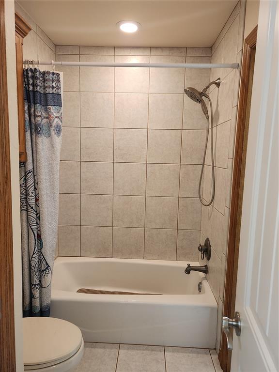 full bathroom with tile patterned flooring, shower / bath combo, and toilet