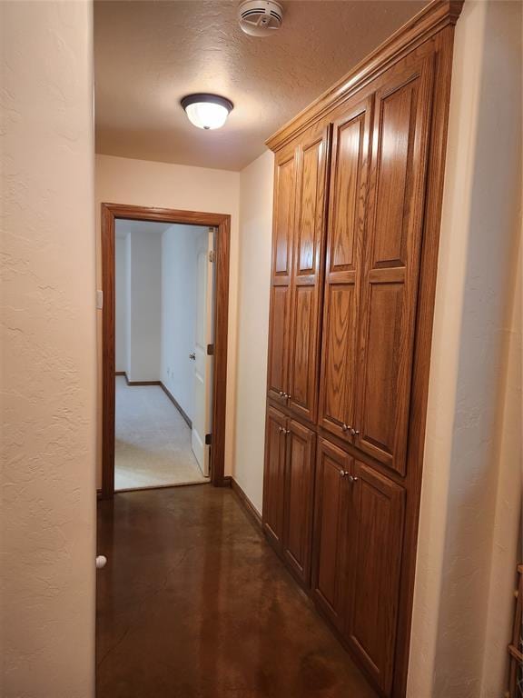 hall featuring finished concrete floors and baseboards