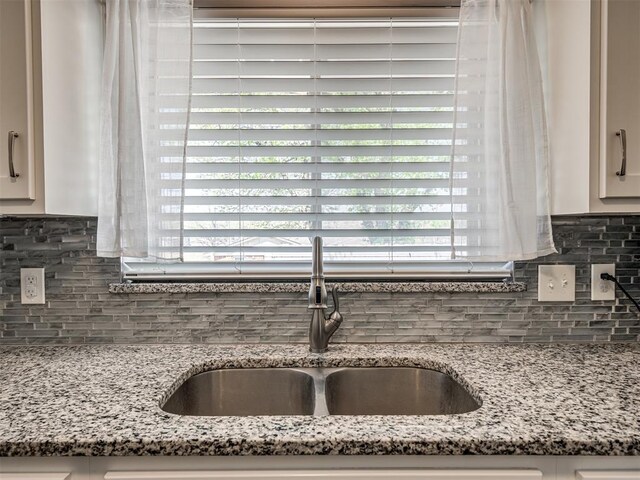 2013 N Draper Ave, Choctaw, OK 73020 - kitchen with white cabinets, light stone counters, decorative backsplash, and a sink