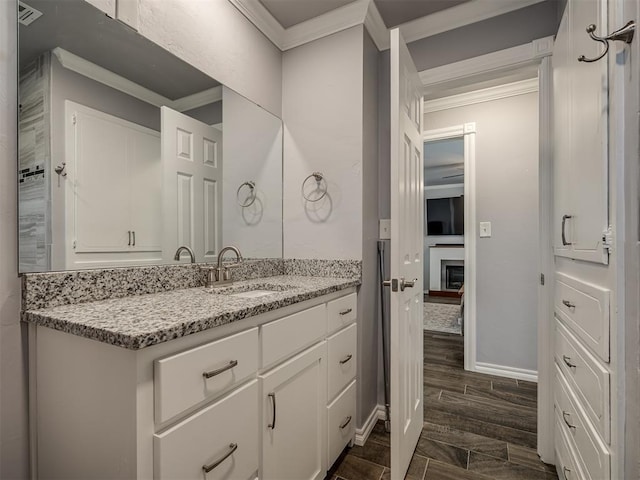 2013 N Draper Ave, Choctaw, OK 73020 - bathroom with crown molding, vanity, baseboards, and wood finished floors
