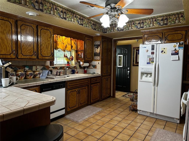 16296 N County Road 3264th Rd, Pauls Valley, OK 73075 - kitchen featuring light tile patterned flooring, white appliances, tile counters, tasteful backsplash, and a ceiling fan