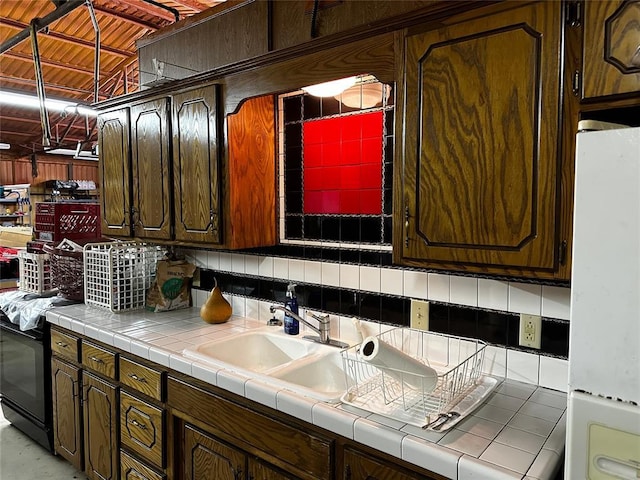 16296 N County Road 3264th Rd, Pauls Valley, OK 73075 - kitchen featuring freestanding refrigerator, dark brown cabinetry, tile counters, a sink, and backsplash