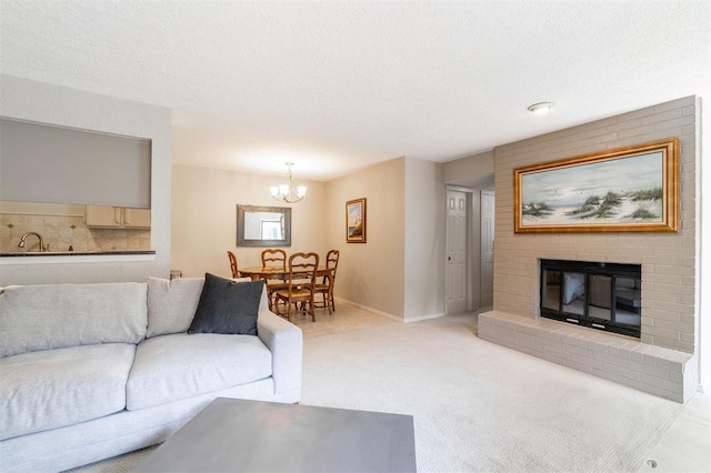 living room with a fireplace, baseboards, a textured ceiling, a chandelier, and carpet