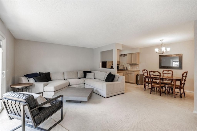 living room featuring light colored carpet, a textured ceiling, and a notable chandelier
