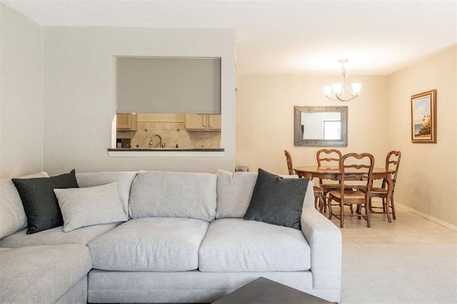 living area with baseboards, a notable chandelier, and light carpet