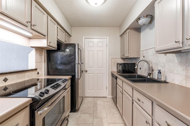 kitchen featuring backsplash, stainless steel appliances, a sink, and light countertops
