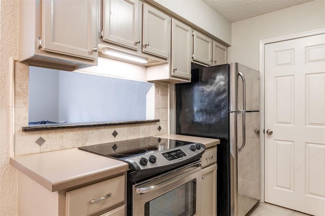 kitchen featuring light tile patterned flooring, light countertops, a textured ceiling, stainless steel appliances, and tasteful backsplash