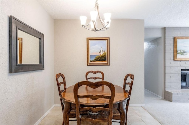 dining space featuring light tile patterned flooring, baseboards, a notable chandelier, and a fireplace