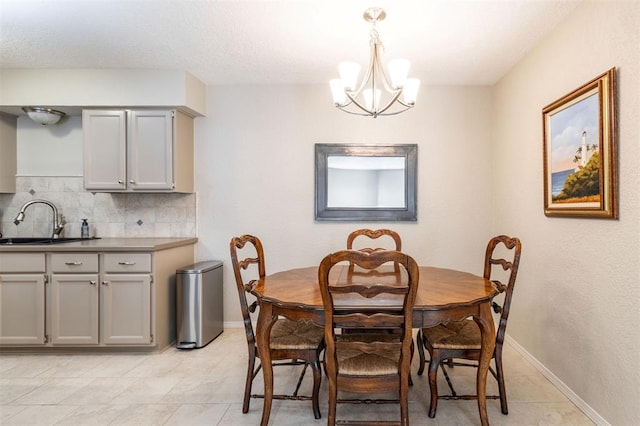 dining area featuring baseboards, light tile patterned floors, and a chandelier