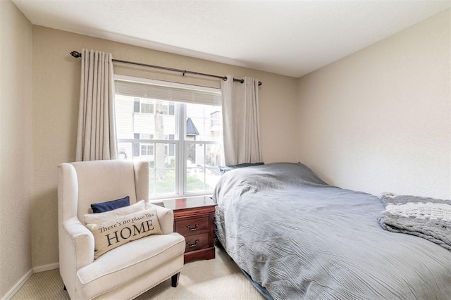 carpeted bedroom featuring baseboards and multiple windows
