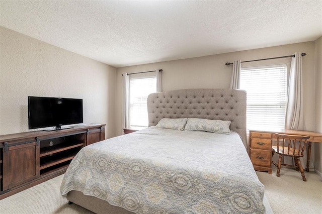 bedroom featuring light colored carpet and a textured ceiling