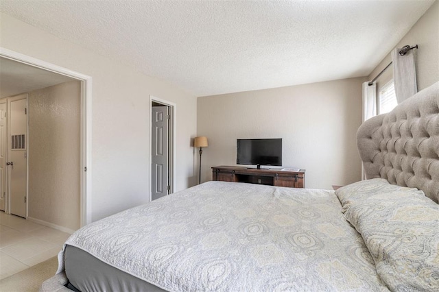 bedroom with a textured ceiling and light tile patterned floors