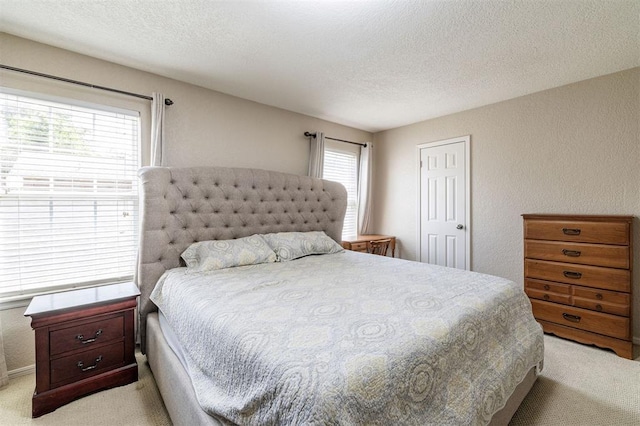 bedroom with a textured ceiling and light colored carpet