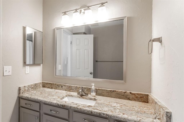bathroom with vanity and a textured wall