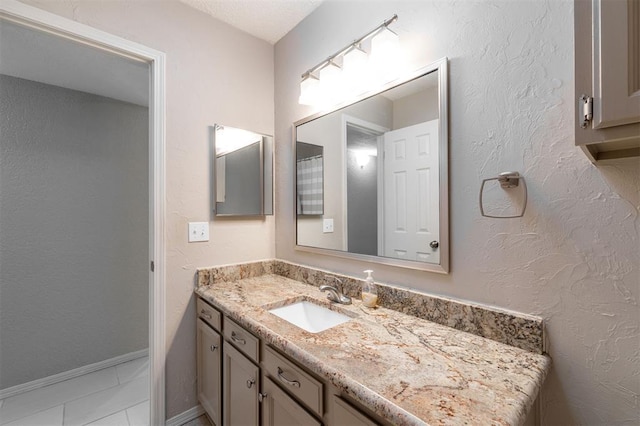 bathroom featuring baseboards, marble finish floor, and vanity