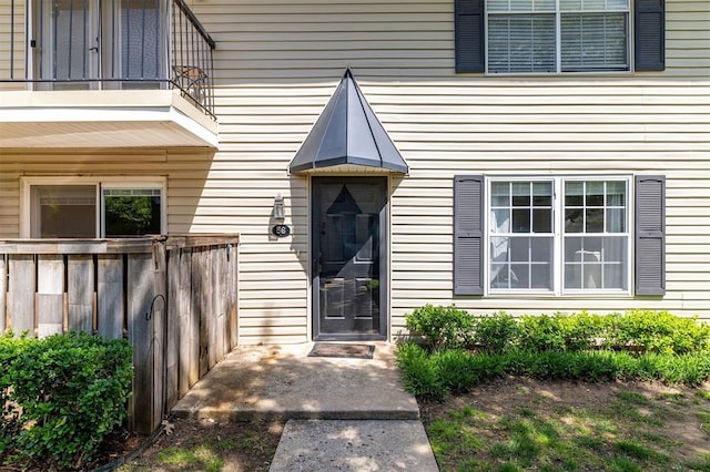 entrance to property with fence and a balcony