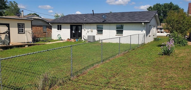 back of house with a fenced backyard, brick siding, and a lawn