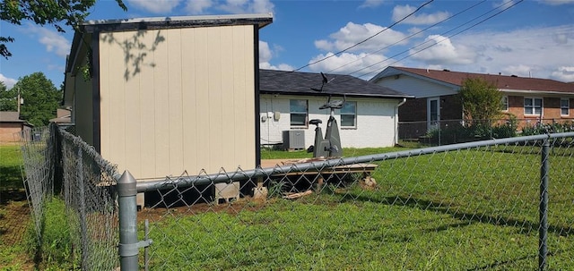 exterior space featuring central AC, a yard, brick siding, and fence