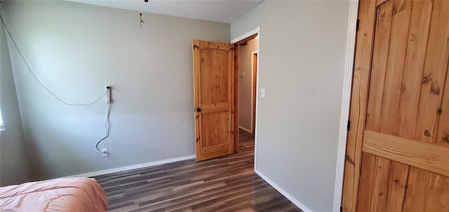 bedroom featuring dark wood-type flooring and baseboards