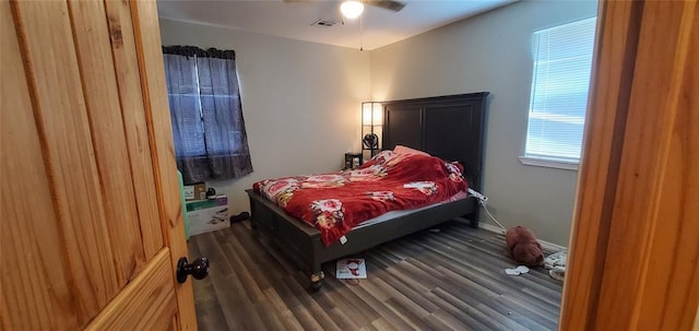 bedroom featuring ceiling fan, visible vents, and wood finished floors