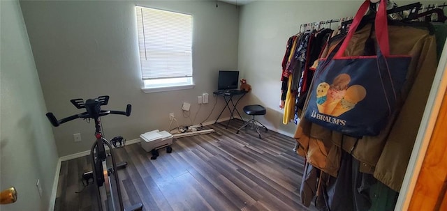 exercise area with baseboards and wood finished floors