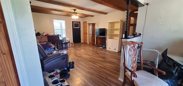 interior space with beamed ceiling, a ceiling fan, and wood finished floors