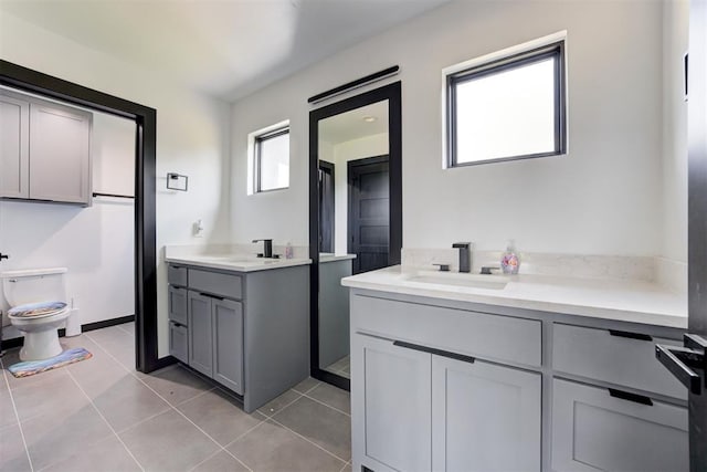 10317 N Hassett Rd, Oklahoma City, OK 73131 - bathroom with two vanities, tile patterned flooring, and toilet