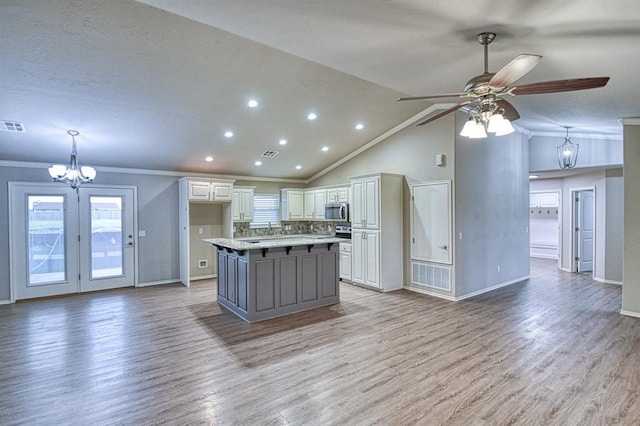 34701 E County Road 1610, Pauls Valley, OK 73075 - kitchen with ceiling fan with notable chandelier, open floor plan, crown molding, white cabinetry, and stainless steel microwave