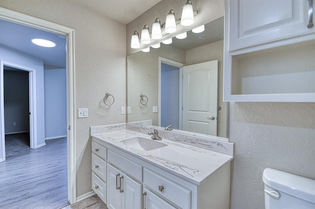 34701 E County Road 1610, Pauls Valley, OK 73075 - bathroom with toilet, baseboards, vanity, and wood finished floors