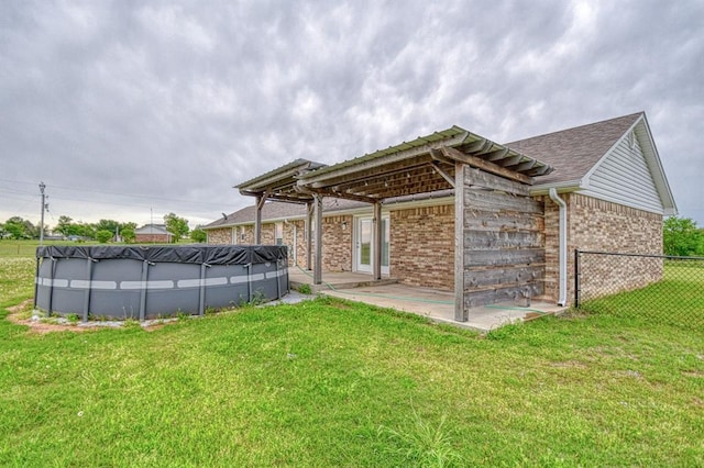 34701 E County Road 1610, Pauls Valley, OK 73075 - back of house with a yard, brick siding, fence, and a fenced in pool