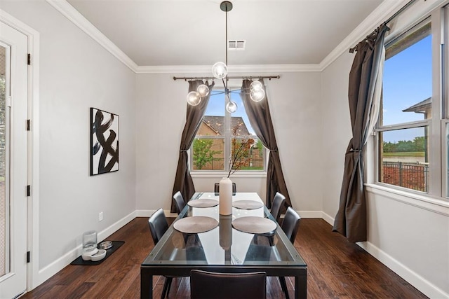 dining room featuring baseboards, ornamental molding, visible vents, and wood finished floors