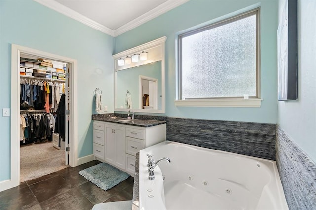 full bathroom featuring crown molding, a jetted tub, vanity, and a spacious closet