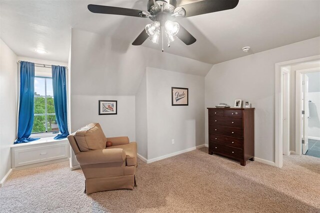 living area featuring carpet, vaulted ceiling, baseboards, and ceiling fan