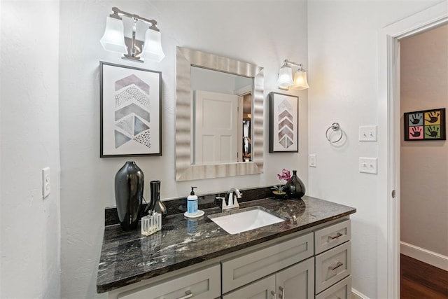 bathroom featuring baseboards, vanity, and wood finished floors