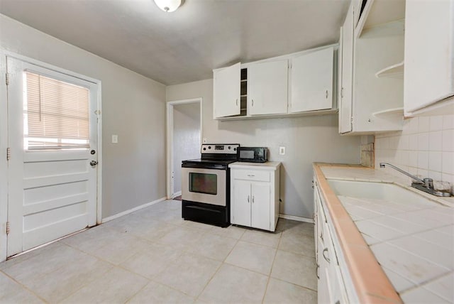 3924 Teal Dr, Del City, OK 73115 - kitchen featuring stainless steel electric range, tile countertops, white cabinets, and baseboards