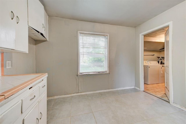 3924 Teal Dr, Del City, OK 73115 - kitchen with washer and clothes dryer, tile counters, white cabinets, and light tile patterned floors